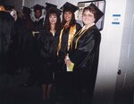 Three students posing together in commencement regalia